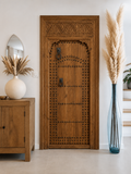 Porte en bois massif sculptée à la main avec arche décorative, fabrication artisanale sur mesure en cèdre.